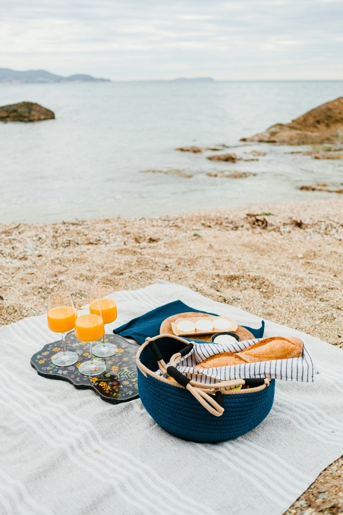 Picknick-Treffen — Strandpicknick, Küstenblick, Macarons und ein Kerzenlicht-Abendtisch